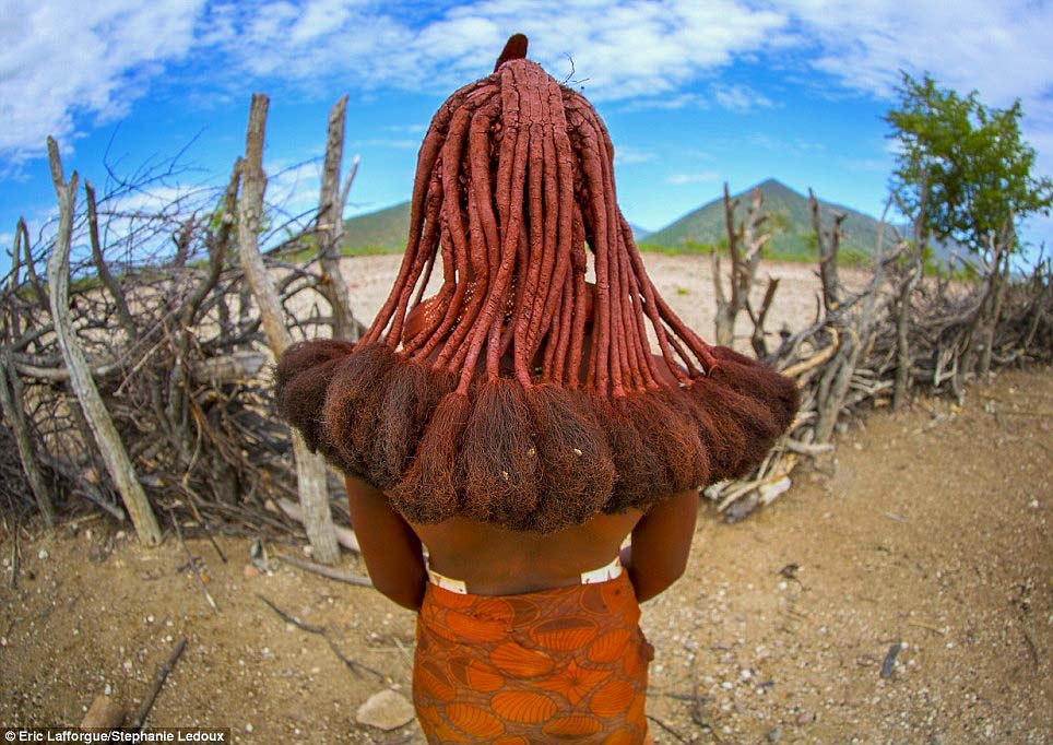 A Himba woman shows off her long dreadlocks, created using a mixture of ground ochre, butter and goat hair