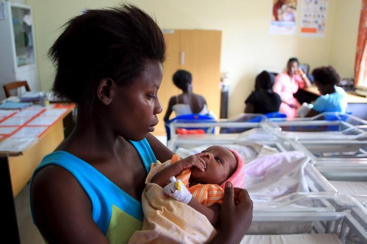 A mother holds her baby after breastfeeding at Kisenyi health centre in Uganda's capital Kampala April 10, 2015. Kisenyi health center in Kampala, which delivers 600 babies a month, symbolizes the shift in Uganda which has seen the country invest more money in the healthcare system to make it accessible for the poorest, Save the Children said. Child deaths in Kampala fell faster than in any other African city between 2006 and 2011 - despite a large influx of refugees from war-torn neighboring states, the charity said in a report. Picture taken April 10, 2015. To match HEALTH-CHILDREN/UGANDA REUTERS/James Akena