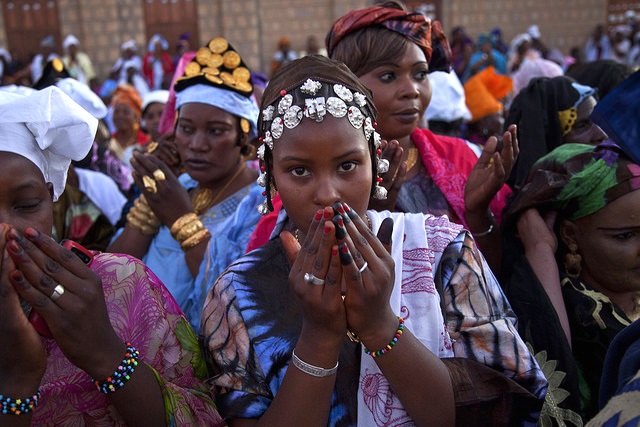 Scenes from the Maouloud Festival in Timbuktu, which was forbidden in 2013 during the Jihadist occupation. Women, wearing traditional clothes, pray outside the Sankore Mosque to celebrate the birth of the Muslim prophet, Muhammed. United Nations Photo /FLickr